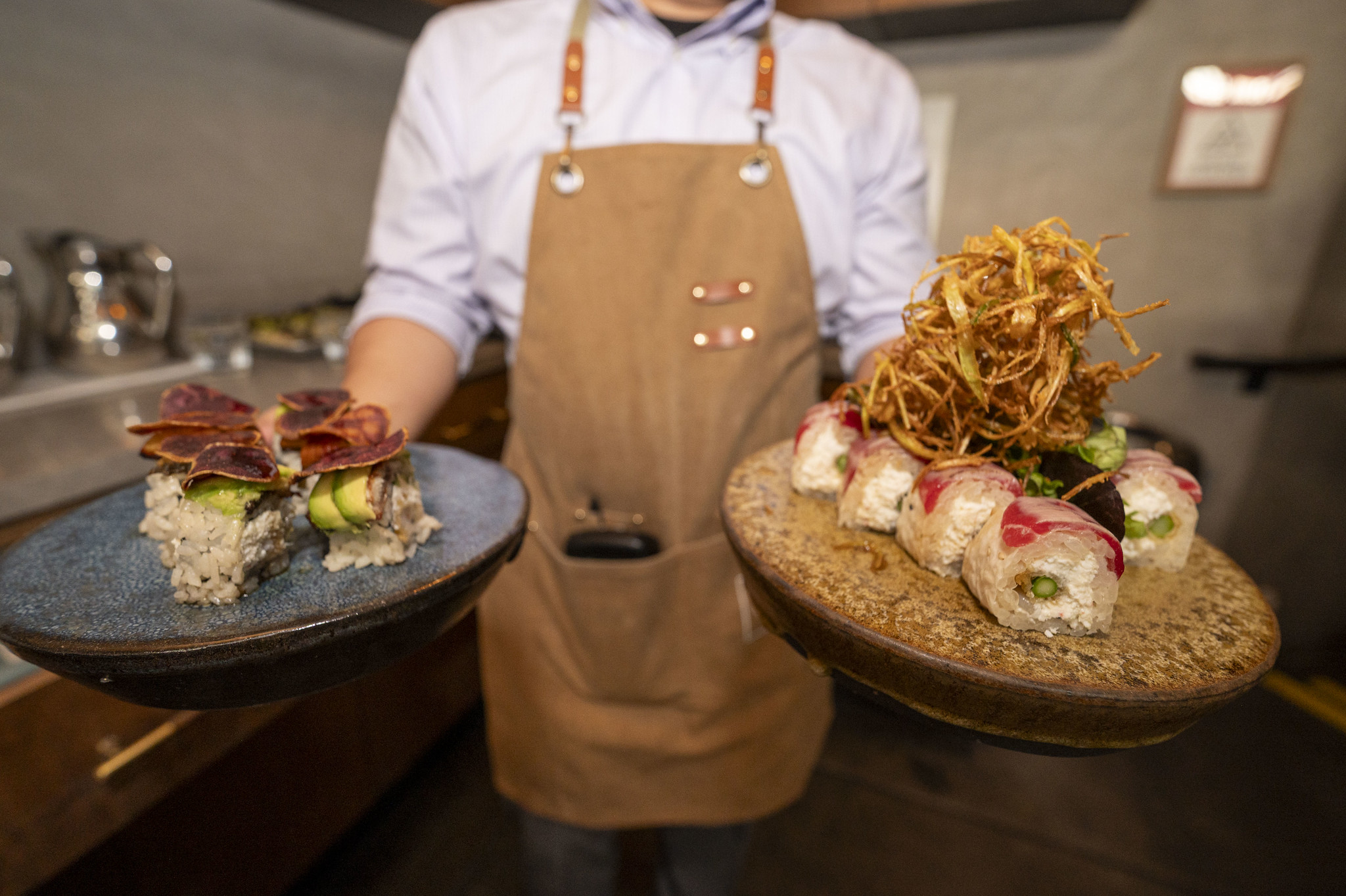 General Manager Kevin Putra presents Azuki's bonsai and r u kidding me? specialty rolls on student-made ceramic dishware.