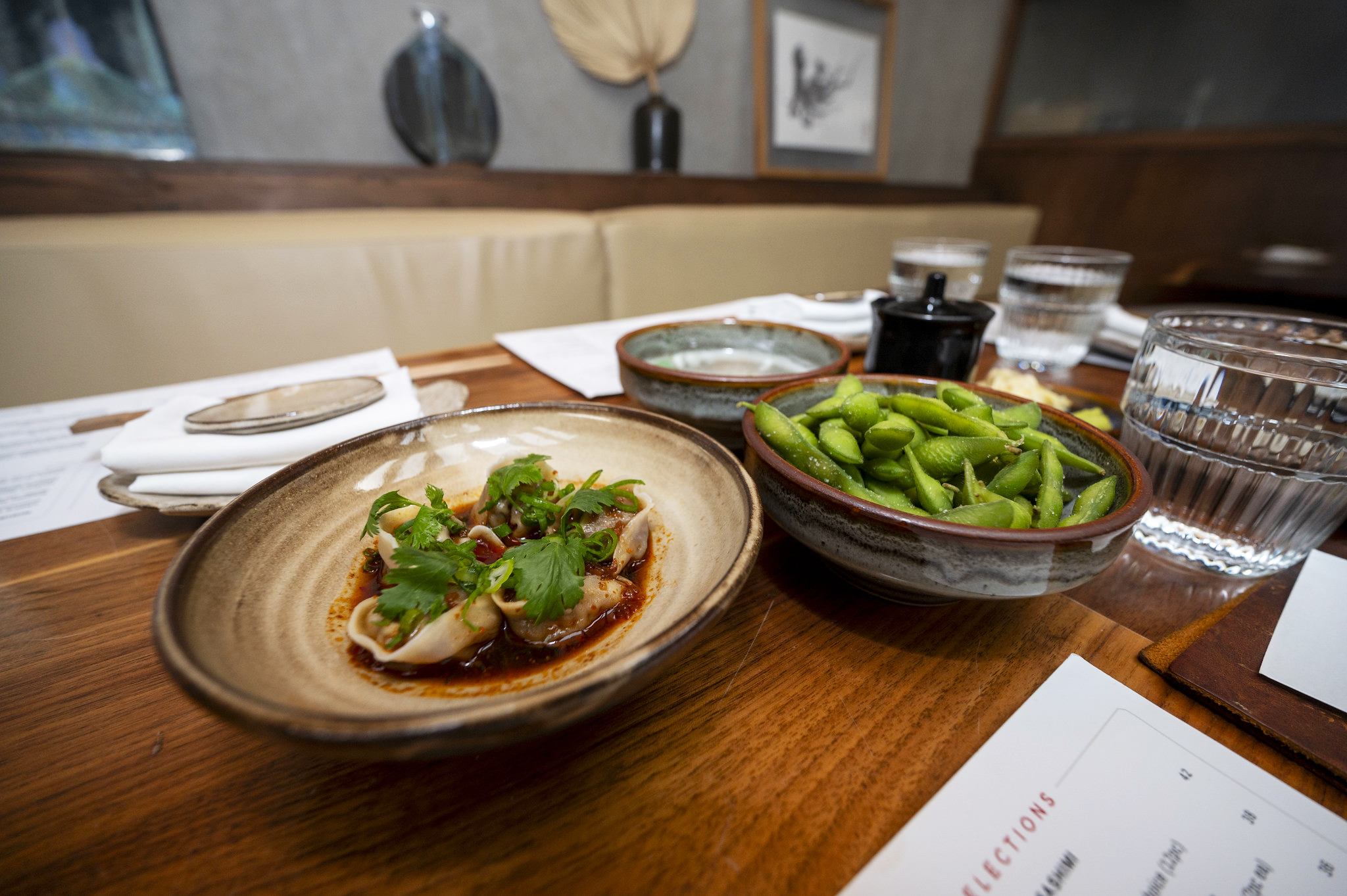 Miyazaki wagyu dumplings and edamame are served on student-made ceramic dishware at Azuki Sushi.