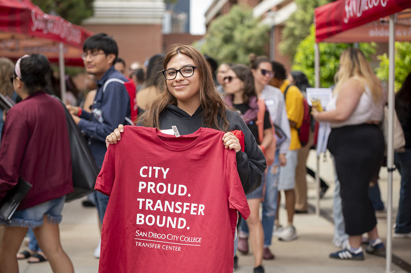 Student holding college tshirt Student holding red City College. Transfer Bound. tshirt