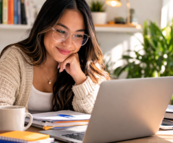 Student studying on a laptop with headphones in a home workspace, representing online learning